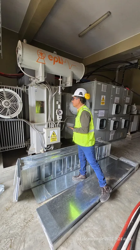 Técnico con EPP completo inspeccionando transformador trifásico EPLI en subestación eléctrica industrial